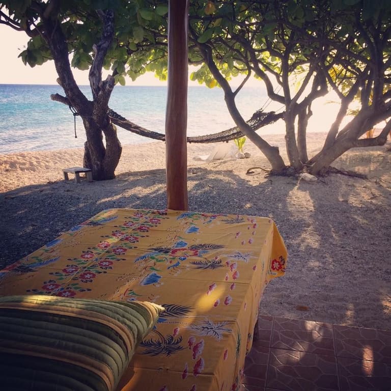 La table du petit-déjeuner dressée sous les arbres, sur la plage