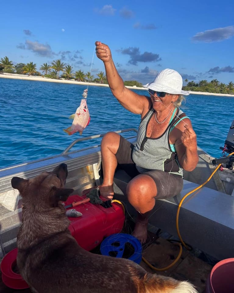Retour de pêche en bateau, poisson à la main