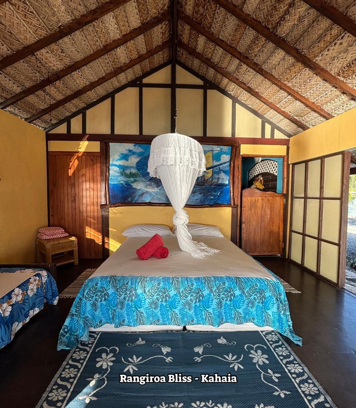 Chambre au lit drapé d’une moustiquaire